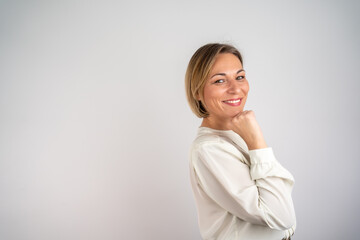 Fototapeta premium Mature beautiful blonde woman over isolated background with hand on chin thinking about question, pensive expression. Smiling with thoughtful face. 