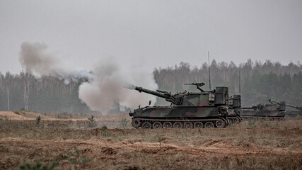 Self propelled howitzer shooting in field