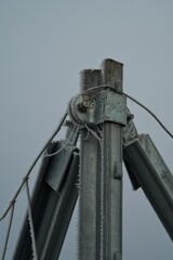 Frost, Nebel und wei&szlig;er Reif auf dem Metallprofil des Zauns. Winterliches minimalistisches Detail mit grauem Hintergrund.