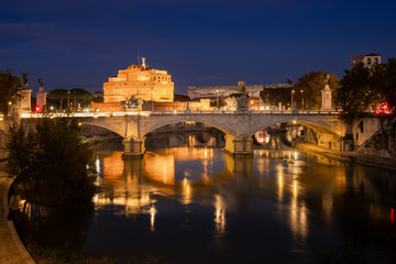 Night scenery of Ponte Vittorio Emanuele II across the River Tiber with Castel Sant'Angelo, a famous landmark in Rome, Italy, in the background.