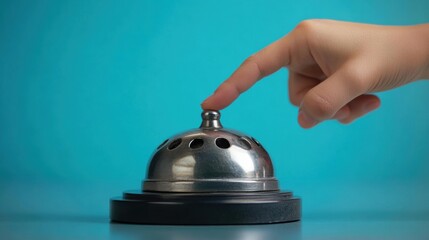 Hand finger touching service bell on desk.