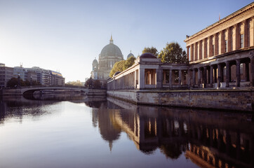 Fototapeta premium view of Museum Island in Berlin during sunrise, with Berlin Cathedral n the background. calm waters of the Spree River reflect the historical architecture