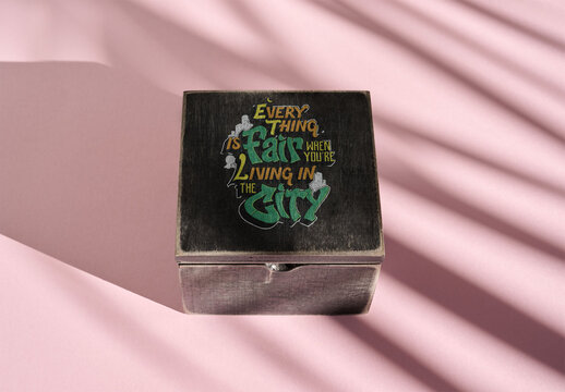 Wooden black Box With Shadows on a Pink Surface in Sunlight