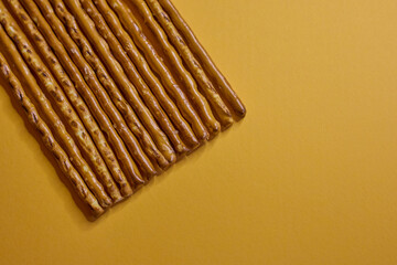 Deliciously Crispy Pretzel Sticks Set Against a Bright Yellow Background for Visual Appeal