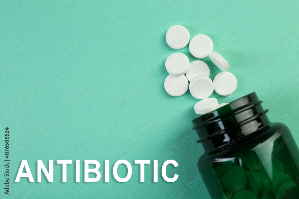 Wall mural Bottle of antibiotic pills on aquamarine background, top view