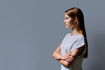 Obraz premium Profile portrait of young teenage girl, gray studio copy space background