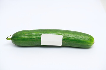 Fresh Cucumber with Blank Label. Close-up of a whole green cucumber with a blank white label attached, isolated on a clean white background for customization.

