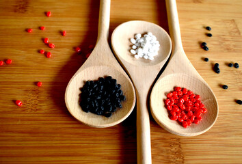 Several colors of beads on wooden spoon