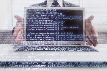 Hands typing on laptop computer with programming code