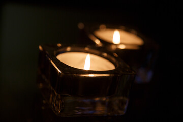 Soft glow of flickering candles illuminates a dark setting creating a calming ambiance for relaxation and reflection
