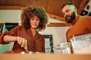 Couple cooking together in modern kitchen, preparing ingredients