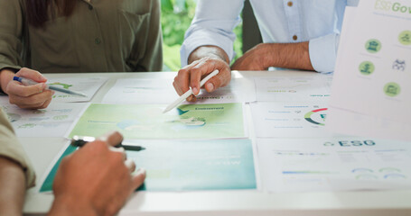 Closeup group Asia businesspeople talk ESG strategies risk management workshop, SDGs report, global warming, green finance investment eco friendly and net zero waste in boardroom training building.