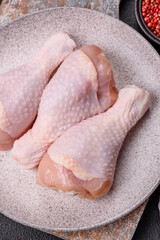 Raw chicken legs with salt, spices and herbs