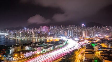 Night cityscape with illuminated highway, city lights, and mountains.