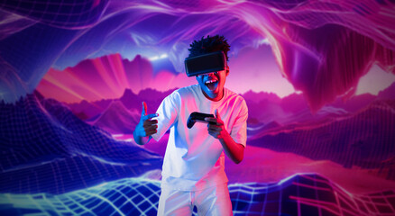 Teenager holding joystick and wearing VR goggles while enjoy playing games at neon abstract...
