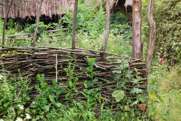Aged wooden fence in countryside. Traditional wooden farmhouse. Village ethnographic museum. Vintage exterior. Sunny day.