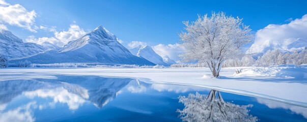 Obraz premium Snow-covered landscape with serene lake reflecting mountains and vibrant blue sky. winter tranquility and nature beauty concept