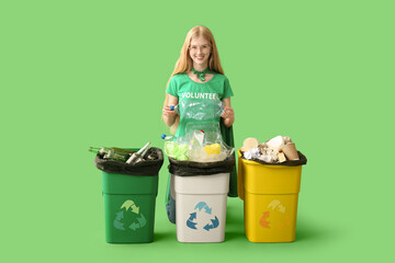 Female volunteer sorting trash on green background