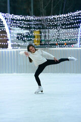Figure skating. Girl skating on the city skating rink.