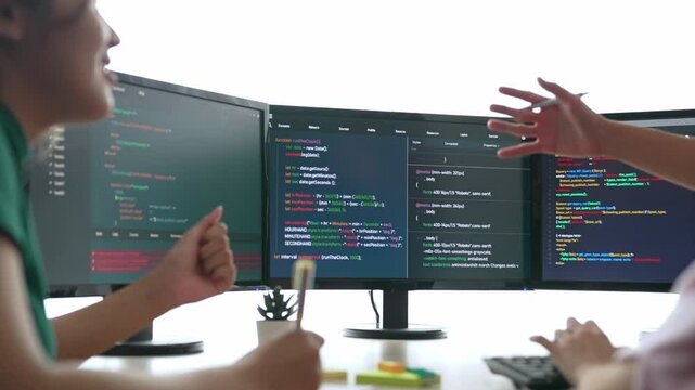 Slow motion back end software developer engineer for computer programming working together on debugging writing computing code, solving complex algorithms display on monitor in office. Burgeoning