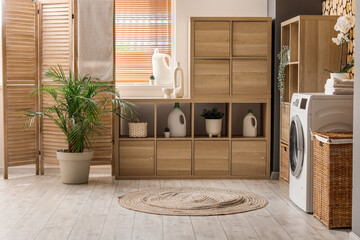 Shelving unit with laundry detergent and washing machine in room