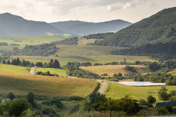 Obraz premium Malowniczy krajobraz górski z polami i drogą
