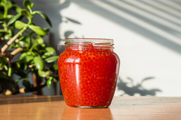 A jar of red caviar on the table