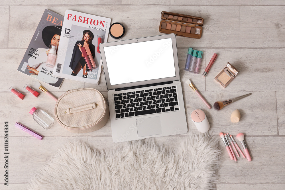 Wall mural Laptop with open beauty blog and makeup products on light wooden floor, top view