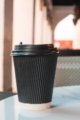 black cardboard coffee cup on table in cafe