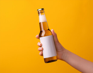 Female hands holding beer bottle on yellow background