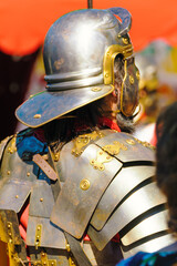 Naklejka premium detail of an ancient roman soldiers, roman legionnaires with helmet and metallic armour armor at a historical festival