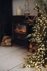 Cozy fireplace with a burning fire in retro style, with firewood and lights