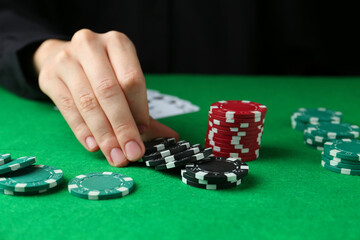Naklejka premium Woman with poker chips at green table, closeup