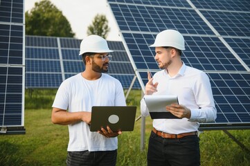 Indian engineer and businessman planing new ecology project. around solar panel