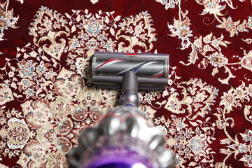 Cleaning carpet with cordless vacuum cleaner indoors, top view