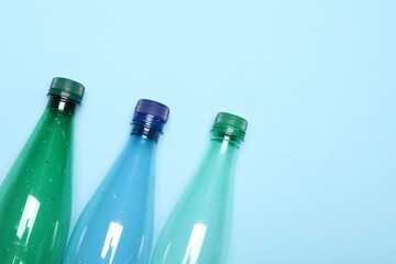 Plastic bottles on light background, top view. Space for text