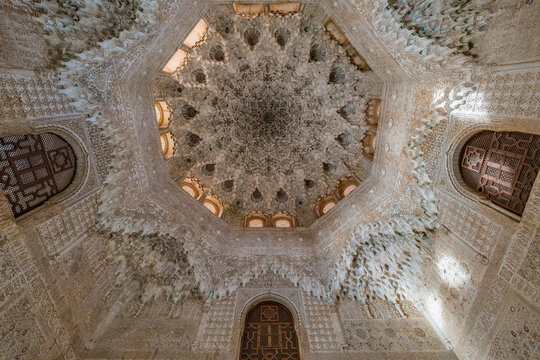 Granada, Spain - November 22, 2022 : Alhambra palace, Sala de las Dos hermanas Two sisters Hall. Upview of octogonal flower Shaped Ceiling dome of mocarabes Stucco-carved muqarnas.