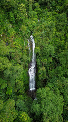 Drone view of Curug Cijalu or Cijalu Waterfalls. Beautiful waterfalls of west java Indonesia.. Majestic waterfall cascading through lush rainforest in tranquil natural setting