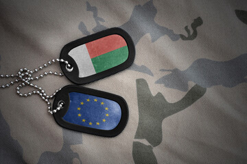 army blank, dog tag with national flag of madagascar and european union on the khaki texture...