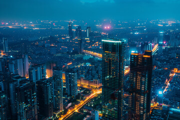 Fototapeta premium City Landscape at Night Illuminated by Vibrant Streetlights, Skyscrapers, and Traffic in a Bustling Modern Metropolis