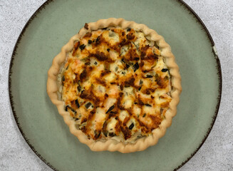Top view of a fresh baked vegetables, cheese and cream pie in a dish on the white marble table	
