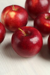 Fresh ripe red apples on white wooden table, closeup