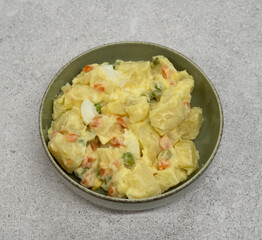 Christmas food. Closeup view of a potatoes, peas, carrot, egg and mayonnaise salad in a bowl	
