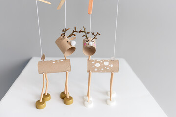 Creative DIY reindeer puppets with wooden stick control made from cardboard tubes and bottle caps....