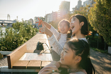 Happy asian family pointing at something while sightseeing in a city park in Tokyo Japan