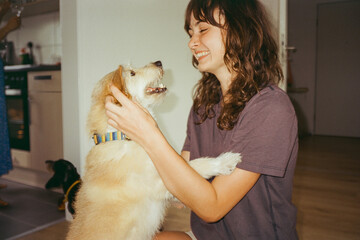 Cheerful woman playing with the dog 