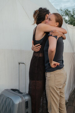 Two women hug goodbye at a campsite