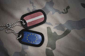 army blank, dog tag with national flag of latvia and european union on the khaki texture...