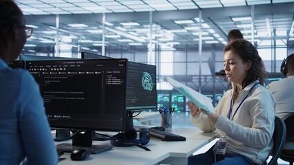 Manager checking project progress of engineer programming in AI data center used for machine...