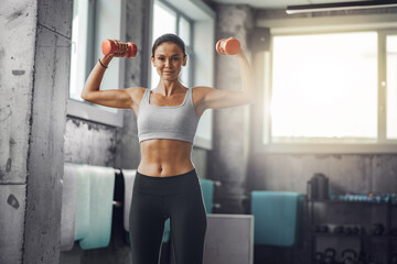 A fit woman is lifting dumbbells, showcasing her incredible strength and determination in a bright,...